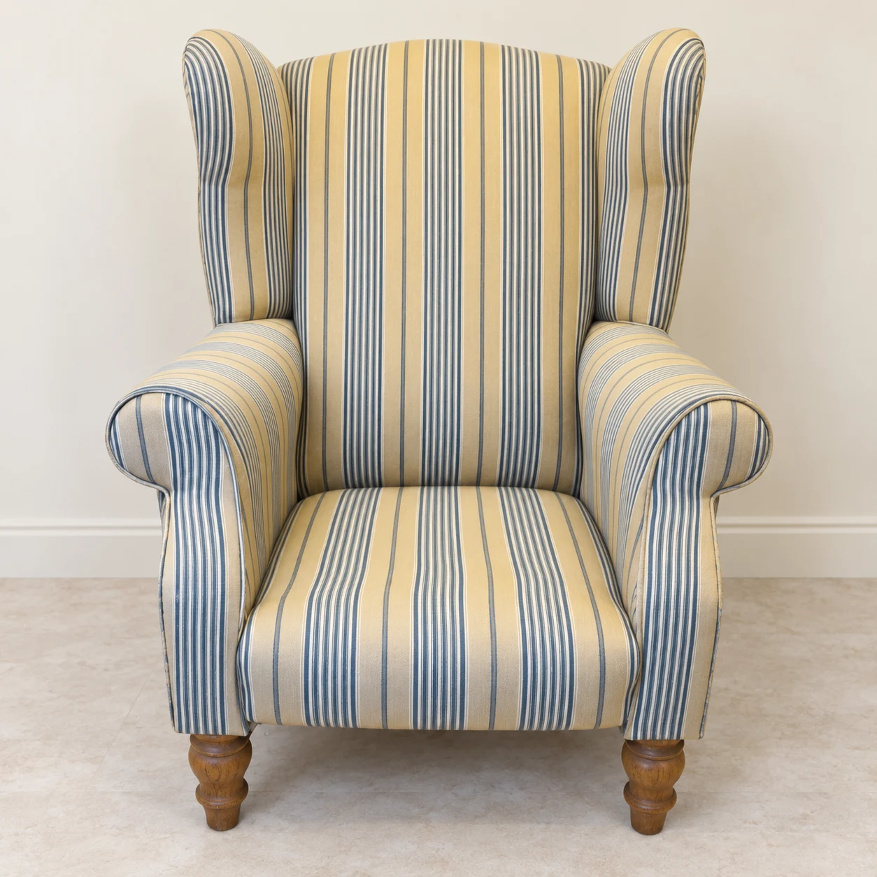 The completed wingback chair with a fresh striped covering.