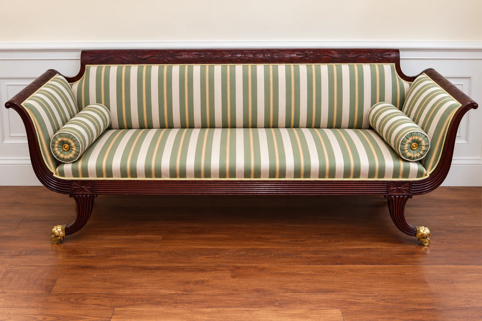 Traditional sofa recovered in sage-striped fabric, retaining its carved wooden frame.